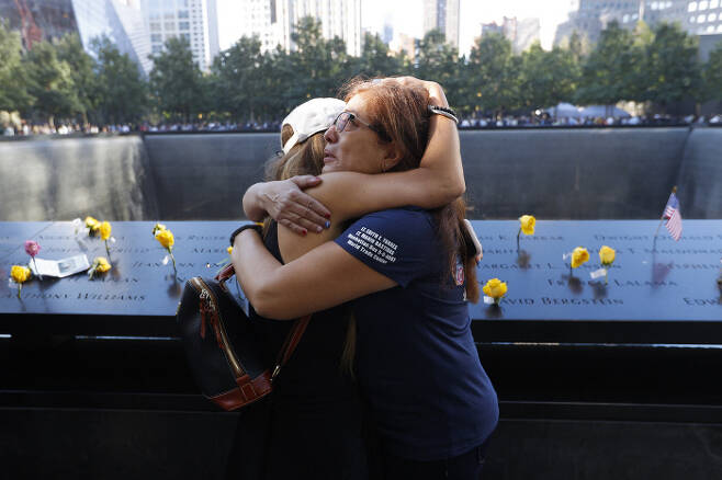 서로의 아픔 위로 11일(현지시간) 미국 뉴욕 ‘그라운드 제로’에 조성된 추모공원에서 9·11테러로 떠나보낸 서로의 가족들이 생전 아는 사이였다는 사실을 알게 된 두 유족이 얼싸안으며 위로하고 있다.   뉴욕 | AP연합뉴스
