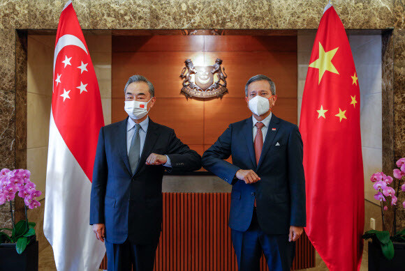 왕이 중국 외교담당 국무위원 겸 외교부장이 13일 싱가포르에서 비비안 발라크리쉬난 싱가포르 외교장관과 회담에 앞서 팔꿈치 인사를 하고 있다. 싱가포르 외교부 제공