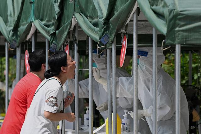 중국에서 신종 코로나바이러스 감염증(코로나19) 델타 변이가 빠르게 확산하는 가운데 5일 베이징에 설치된 핵산 검사소에서 주민들이 검체 체취를 받고 있다. AFP 연합뉴스
