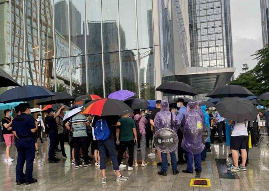헝다그룹 때문에 손해를 입은 투자자와 상품 구매자들이 14일(현지시간) 비가 내리는 속에서도 중국 광둥성 선전의 헝다그룹 본사 앞에서 시위를 하고 있다.   [이미지 출처= 블룸버그AFP]