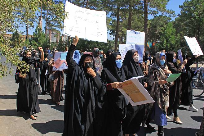 아프가니스탄 헤라트에서 9월 2일(현지시간) 여성들이 플래카드를 들고 시위를 벌이고 있다. 이들은 딸들이 탈레반 치하에서도 학교에 갈 수  있다면 전신을 가리는 부르카 착용을 받아들이겠다고 말했다. /AFP연합뉴스