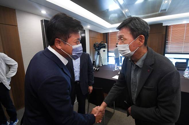 박정호 SK텔레콤 대표(왼쪽)와 황현식 LG유플러스 대표가 악수하고 있다.