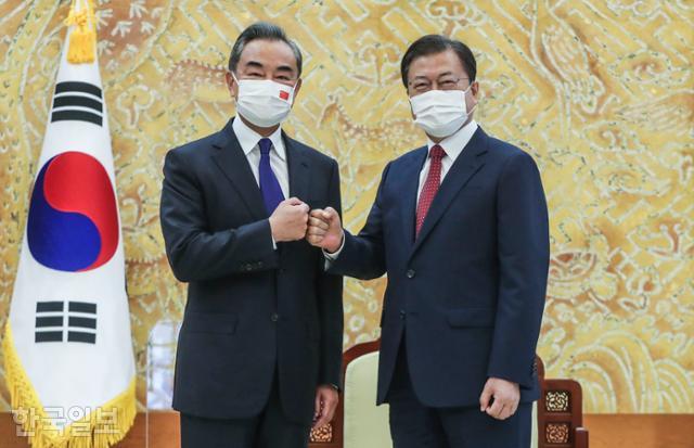 문재인(오른쪽) 대통령이 15일 청와대에서 왕이 중국 외교부장과 주먹인사를 하고 있다. 왕태석 선임기자