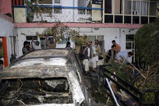 지난달 29일 아프가니스탄 카불에서 미군이 테러를 사전에 차단하기 위해 드론으로 공습한 차량을 주민들이 살펴보고 있다. 카불=AP 연합뉴스