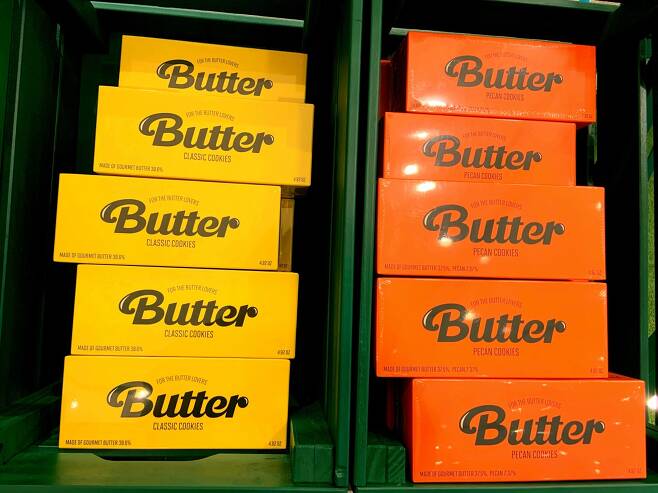 Orange and yellow boxes of cookies named after BTS’ megahit song “Butter” are displayed on a rack. (Park Jun-hee/The Korea Herald)