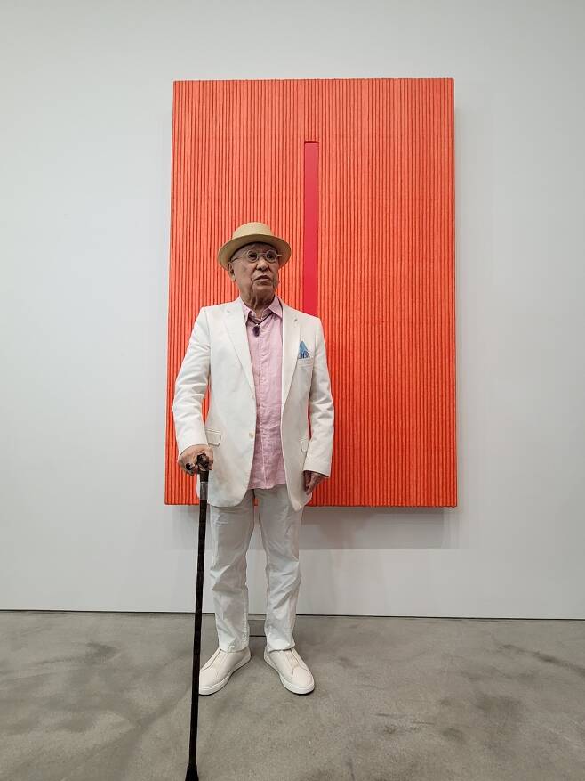 Park Seo-bo poses in front of his painting inspired by ripe persimmon at Kukje Gallery (Park Yuna/ The Korea Herald)
