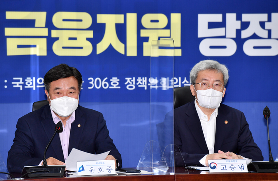 Democratic Party floor leader Yun Ho-jung, left, and FSC Chairman Koh Seung-beom speak during a meeting at the National Assembly on Wednesday. The DP and the government agreed to extend the debt suspension program for another six month. [YONHAP]