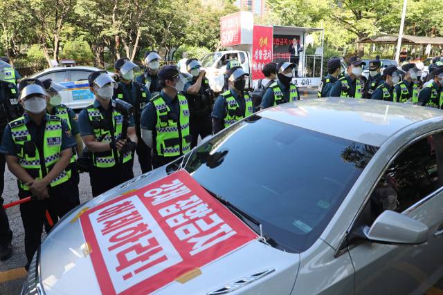 한국유흥음식업중앙회 수도권 회원들이 15일 국회 앞에서 코로나19 방역 조치인 집합금지 해제를 촉구하는 기자회견을 하고 있다. /연합뉴스