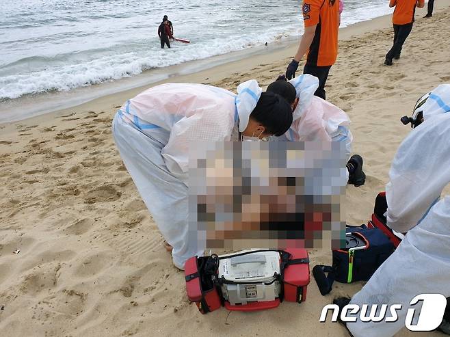119구조대가 물에 빠진 남성에 대해 응급처치를 하고 있다(부산경찰청제공)© 뉴스1