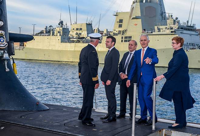 2018년 5월2일, 에마뉘엘 마크롱 프랑스 대통령(왼쪽 두번째)이 당시 호주 총리 말콤 턴불(오른쪽 두번째)과 함께 호주 해군이 보유한 콜린스급 잠수함의 갑판에 올라 얘기를 나누고 있다. '오커스' 딜로 인해, 프랑스가 진행하던 호주의 전기-디젤 잠수함 건조 프로젝트는 폐기될 예정이다./AFP 연합뉴스