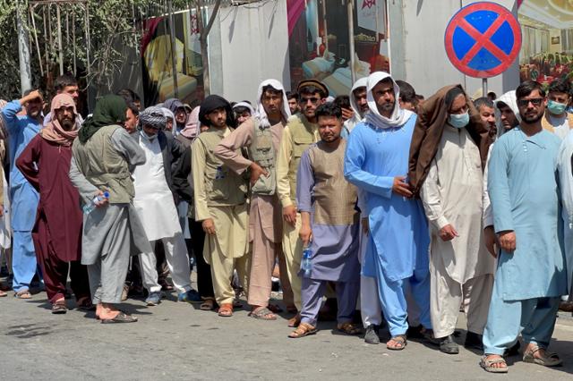 아프가니스탄 수도 카불 내 은행 잠정 폐쇄로 현금이 부족해진 사람들이 1일 한 은행 바깥에서 현금을 인출하기 위해 길게 줄 서 있다. 카불=로이터 연합뉴스