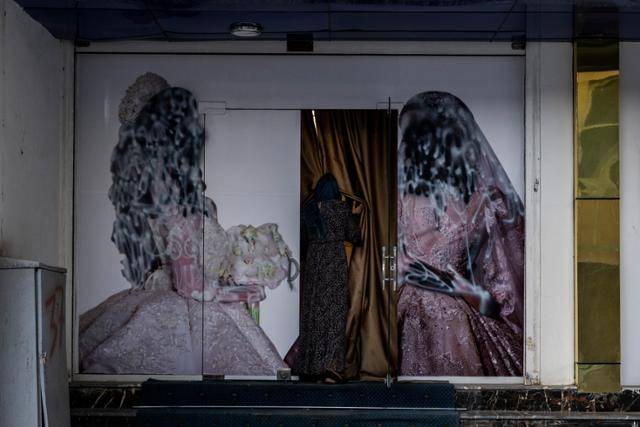 11일 아프가니스탄 카불에서 한 여성이 미용실 안으로 들어가고 있다. 여성 모델들의 사진이 훼손돼 있는 모습이 아프간 여성 인권의 현주소를 상징적으로 보여 주고 있다. 카불=AP 연합뉴스