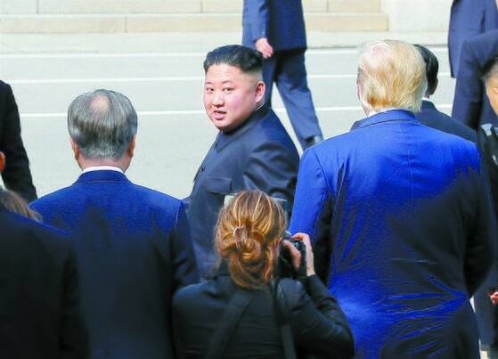 북한 김정은 국무위원장이 2019년 6월 30일 판문점에서 문재인 대통령과 도널드 트럼프 당시 미국 대통령의 배웅을 받으며 군사분계선을 넘어 북측으로 돌아가다 뒤돌아보고 있다. 연합뉴스