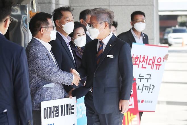 이재명 경기도지사가 지난 15일 오전 경기도 수원시 경기도의회에서 열린 제354회 임시회 제4차 본회의에 출석하기 위해 이동하며 피켓시위 중인 경기도의회 국민의힘 의원들과 인사하고 있다. 연합뉴스
