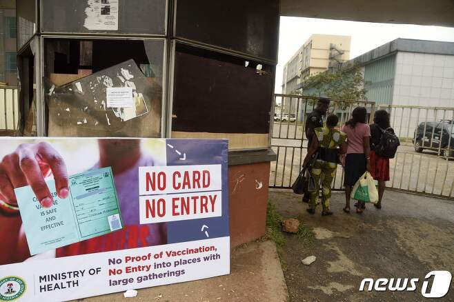 아프리카 나이지리아 남부 에도 주도 벤인에서 한 보안대원이 16일(현지시간) 코로나19 백신 패스를 검사하고 있다. 2021.09.16 © AFP=뉴스1