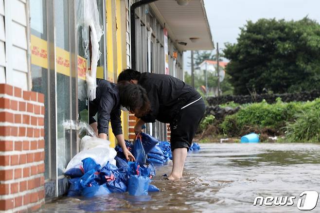 17일 오전 제14호 태풍 '찬투(CHANTHU)'로 인해 침수된 제주시 용담 2동의 한 건물에서 관계자들이 복구 작업을 하고 있다.2021.9.17/뉴스1 © News1 홍수영 기자