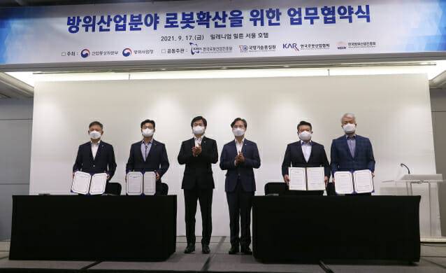 한국로봇산업진흥원, 국방기술품질원, 한국로봇산업협회, 한국방위산업진흥회가 업무협약을 갖고 기념사진을 촬영하고 있다.