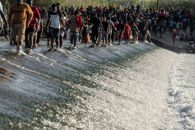 미국 텍사스주 델리오와 멕시코 국경에서 미국 입국을 기다리는 아이티 이민자 수천명이 난민촌을 형성했다고 17일(현지시각) 로이터는 전했다. 사진은 이민자들이 식량을 얻기 위해 인근 리오 그란데 강을 건너는 모습 /로이터 연합뉴스