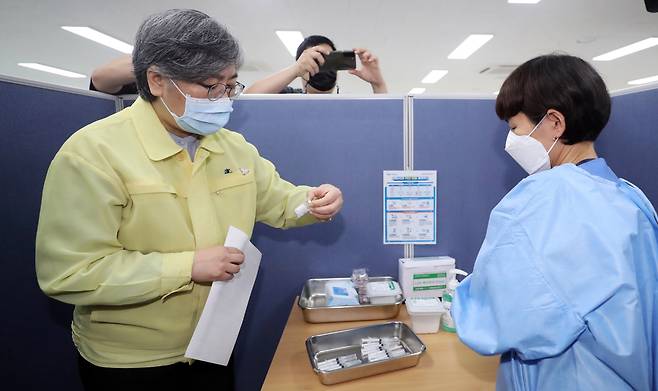 Jeong Eun-kyeong, the chief of the Korea Disease Control and Prevention Agency, (left) speaks with health care providers at a COVID-19 vaccination clinic in Cheongju, North Chungcheong Province, on Friday. (Yonhap)