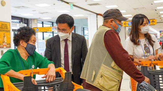 이신사 남군산교회 목사(정장)가 지난 16일 이마트 군산점에서 쇼핑을 마치고 나온 지역 어르신과 이야기를 나누고 있다.