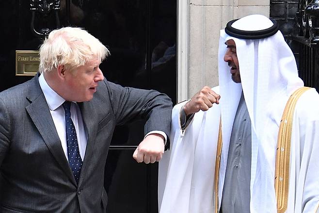 보리스 존슨(왼쪽) 영국 총리가 16일(현지시간) 런던 총리 관저를 방문한 아랍에미리트(UAE)의 실권자 셰이크 모하메드 빈 자이드 알 나얀 아부다비 왕세제와 팔꿈치를 부딪히며 인사하고 있다. [AFP]