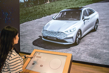 강서 플래그십 스토어를 방문한 고객이 ‘3D 컨피규레이터’를 통해 차량을 3D 이미지로 체험하고 있다. [기아 제공]