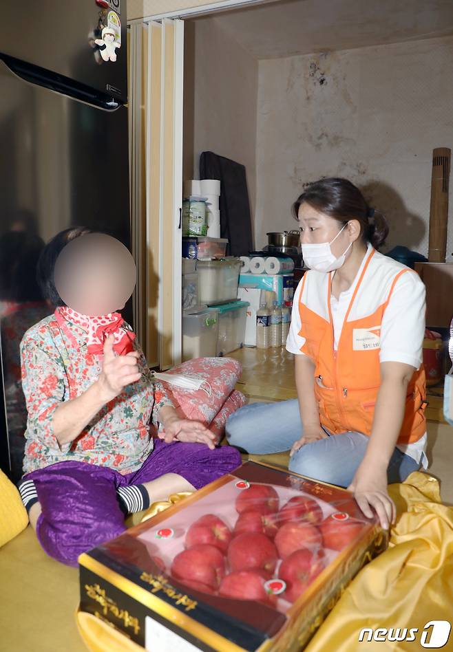 지난 16일 오후 광주 서구 광천동 한 가정에서 이은숙 월드비전 무진종합사회복지관 과장이 독거노인에게 명절 선물 꾸러미를 전달하고 있다. 2021.9.18/뉴스1