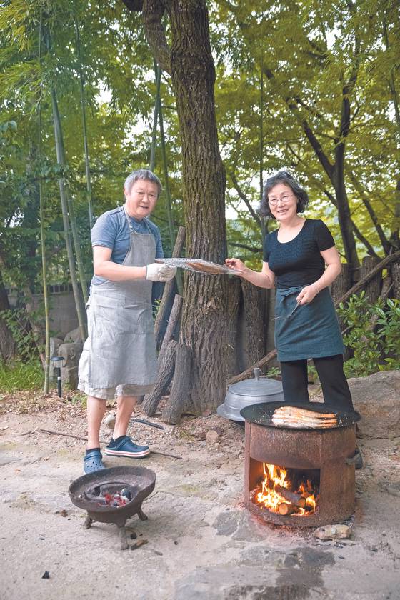 도자기 굽는 신경균씨(왼쪽)와 동갑내기 아내 임계화씨가 준비한 가을 제철 요리가 장작불 위 가마솥 뚜껑에서, 화로 위 석쇠에서 맛있게 익고 있다. 박종근 기자