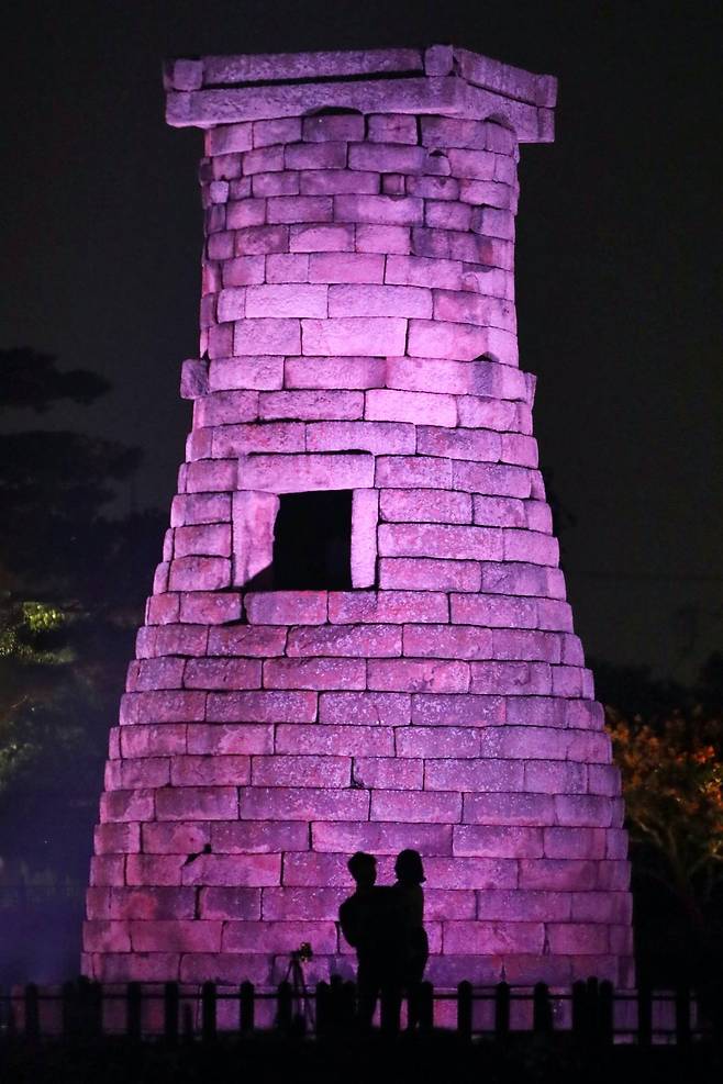 A couple is silhouetted in front of Cheomseongdae, the oldest surviving astronomical observatory in the world. It was constructed in 633 in the Silla Kingdom, in Gyeongju, North Gyeongsang Province.Photo © 2020 Hyungwon Kang