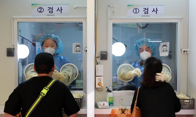 안철수(오른쪽) 국민의당 대표가 18일 오전 서울 중구보건소 선별진료소에서 의료자원 봉사를 하고 있다. 뉴시스