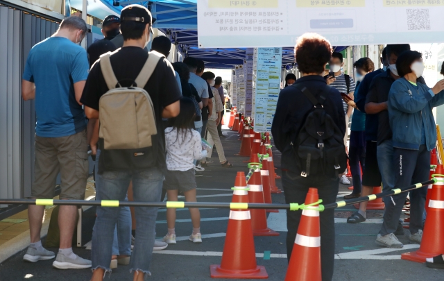 18일 오전 서울 중구보건소 선별진료소를 찾은 시민들이 코로나19 검사를 받기 위해 대기하고 있다. 뉴시스