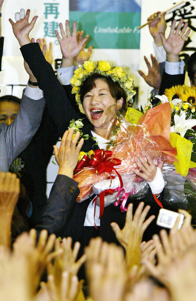 자민당 의원 출신의 반란파로 여성 총리 물망에까지 올랐던 노다 세이코 의원이 2005년 8월 치러진 일본 중의원 선거에서 고이즈미 준이치로 총리의 브레인으로 활약했던 이코노미스트 사토 유카리를 누르고 당선이 확정된 후 지지자들과 함께 팔을 높이 들고 기뻐하고 있다. AFP 연합뉴스