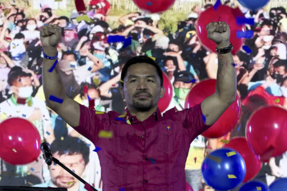 필리핀의 복싱 영웅 매니 파퀴아오 상원의원이 19일(현지시간) 열린 PDP 라반 내 자신이 이끄는 계파가 개최한 전당대회에서 대통령 후보 지명을 수락하며 손을 흔들고 있다. 케손시티=AP연합