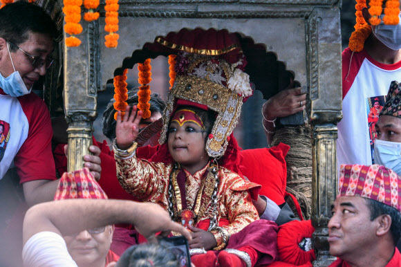 지난 19일(현지시간) 네팔 카트만두 바산타푸르 광장에서 힌두교인들의 축제인 인드라 자트라(Indra Jatra·옌야)가 열린 가운데, 살아 있는 신 ‘쿠마리’가 가마를 타고 행차하고 있다. 카트만두=AFP연합