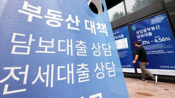 서울의 한 은행지점 외벽에 걸린 대출상담 광고 앞을 한 시민이 지나가고 있다.연합뉴스