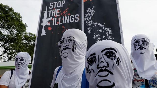 눈물 흘리는 얼굴을 그려넣은 하얀 천으로 본래 얼굴을 가린 필리핀 시위대가 '마약과의 전쟁'을 멈추라고 필리핀 정부에 촉구하는 모습. 마닐라=로이터 연합뉴스