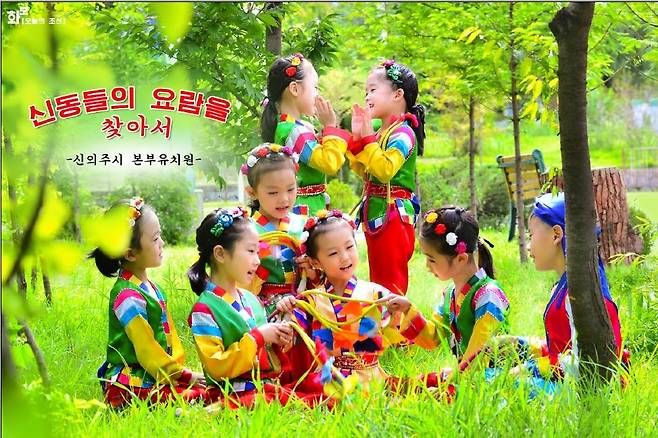 색동옷을 입고 잔디밭에서 놀고 있는 북한 유치원생들 [북한 대외용 화보 '조선' 9월호 캡처. 재판매 및 DB 금지]