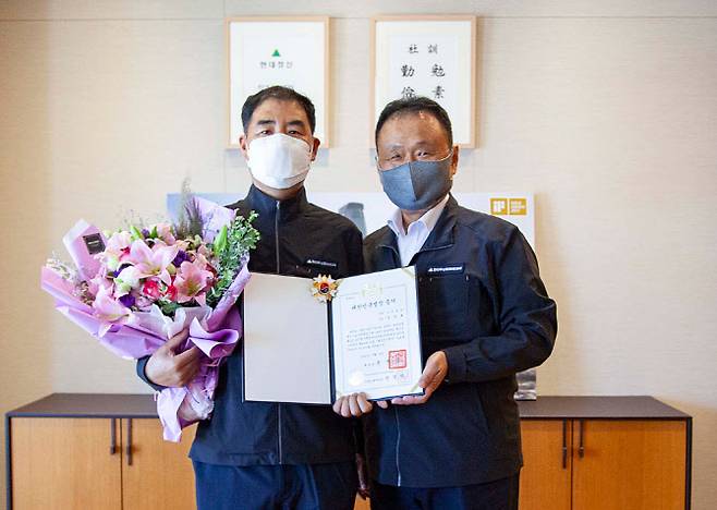 손동연(오른쪽) 현대두산인프라코어 사장이 기계정비 분야 대한민국 명장에 선정된 김주호 현대두산인프라코어 기술부장을 축하하고 있다. (사진=현대두산인프라코어)