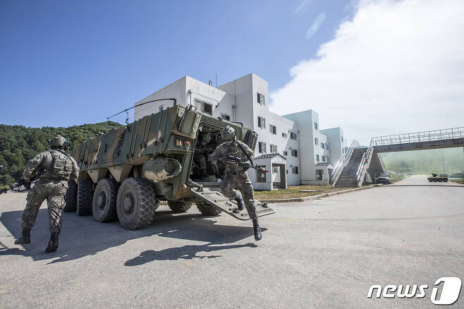 Army TIGER 4.0 전투실험 현장에서 워리어플랫폼을 착용한 전투원들이 K808 차륜형장갑차에서 하차한 후 적진으로 진입하고 있다.(육군 제공)© 뉴스1