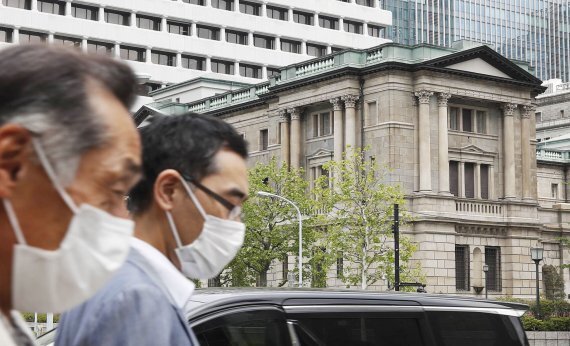 일본 도쿄 일본은행(BOJ) 앞으로 마스크를 쓴 사람들이 걸어가고 있다. 자료사진. AP뉴시스