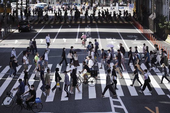 20일 마스크를 쓴 시민들이 일본 도쿄 시내의 횡단보도를 건너고 있다. [AP=연합뉴스]