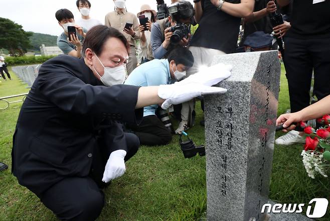 윤석열 전 검찰총장이 올해 7월 6일 오전 대전 유성구 국립대전현충원에서 천안함46용사 묘역을 찾아 참배한 뒤 묘비를 어루만지고 있다. 2021.7.6/뉴스1