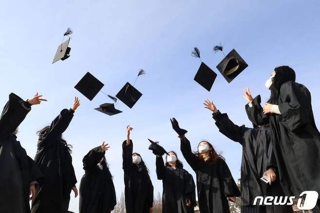경북 경산 영남대에서 졸업생들이 학사모를 던지며 졸업을 축하하고 있다.  2021.2.23/뉴스1 © News1 공정식 기자