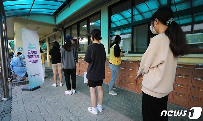 23일 오전 서울 중구 한 중학교에서 추석 연휴 이후 학생 확진자 확산을 막기 위해 마련된 이동식 PCR 검사소에서 학생과 교직원들이 검사를 받기 위해 줄지어 기다리고 있다. © News1 박지혜 기자