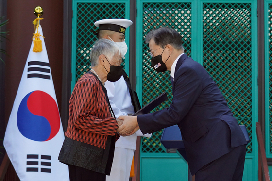 President Moon Jae-in, right, presents posthumously an Order of Merit for National Foundation to the late Kim No-di for her contributions to the Korean independence movement against Japan, accepted by her descendent at a ceremony held at the Korean Language Flagship Center at the University of Hawaii at Manoa Wednesday. [YONHAP]