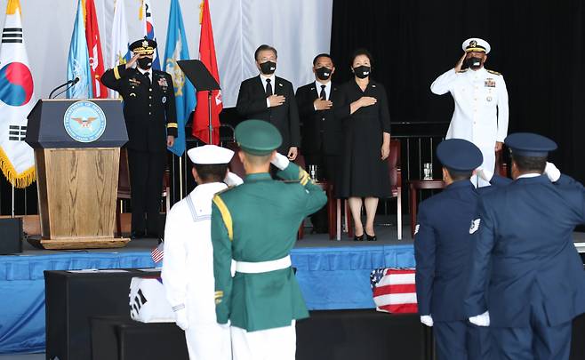 문재인 대통령과 김정숙 여사가 22일(현지시각) 미국 히캄 공군기지 19번 격납고에서 열린 한미 유해 상호 인수식에서 국민의례 하고 있다. 연합뉴스