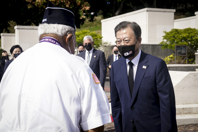 문재인 대통령이 22일(현지시각) 미국 하와이 펀치볼 국립묘지에서 한국전 참전용사들과 인사하고 있다. /연합뉴스