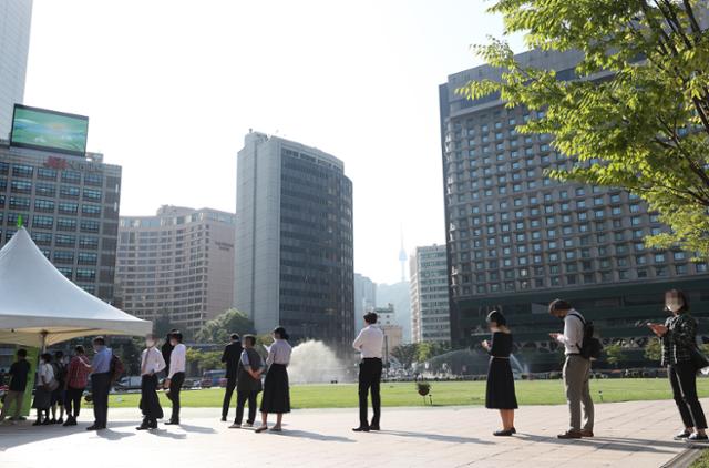 24일 오전 서울광장에 설치된 임시선별검사소에서 시민들이 코로나 검사를 받기 위해 줄을 서 있다. 연합뉴스