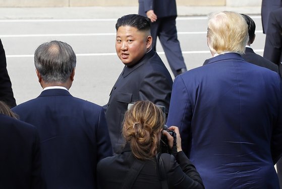 김정은 북한 국무위원장이 2019년 6월 판문점에서 문재인 대통령과 도널드 트럼프 미국 대통령의 배웅을 받으며 군사분계선을 넘어 북측으로 돌아가다 뒤돌아보고 있다. [청와대사진기자단]