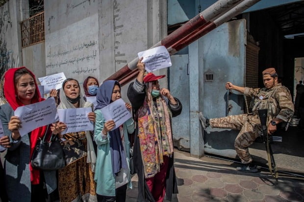아프가니스탄 수도 카불의 전 여성부 청사 앞에서 탈레반 대원이 지켜보는 가운데 여성 권리 증진을 요구하는 시위가 벌어지고 있다. 탈레반 과도정부는 최근 여성부를 폐쇄하고 이른바 '기도·훈도 및 권선징악부'를 신설했다. /사진=AFP
